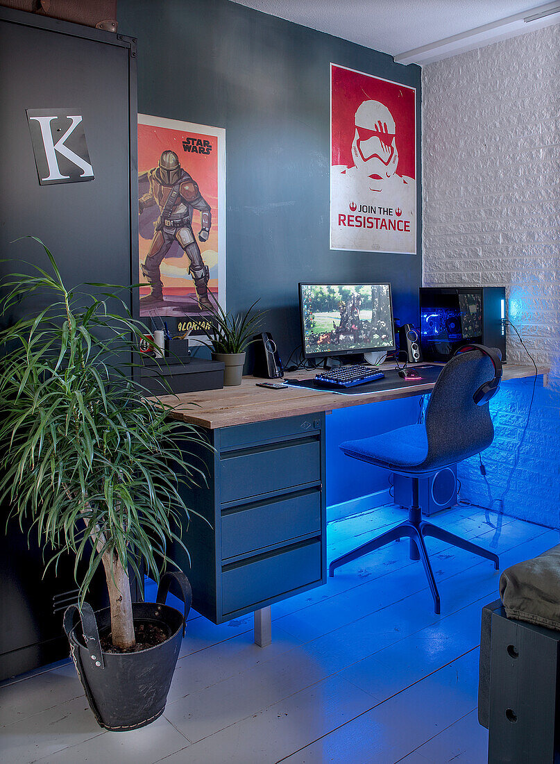 Desk with gaming set-up and Star Wars posters in the youth room