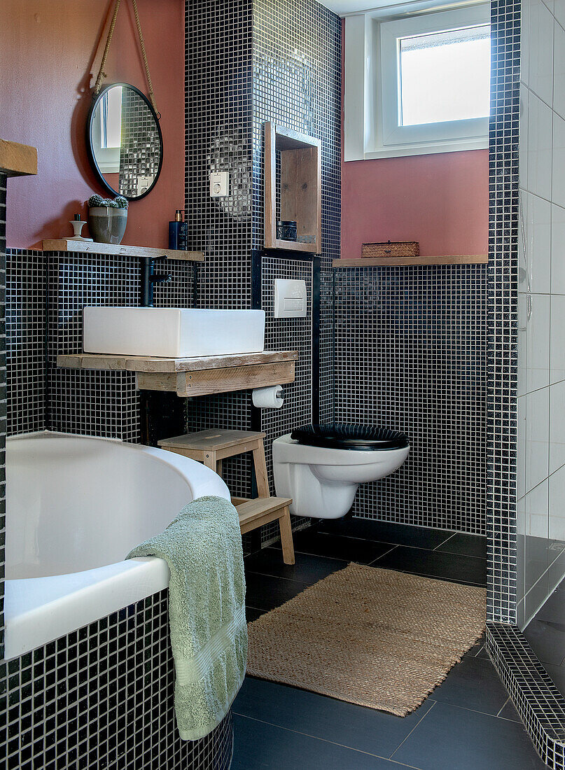 Modern bathroom with black and white mosaic tiles and bathtub