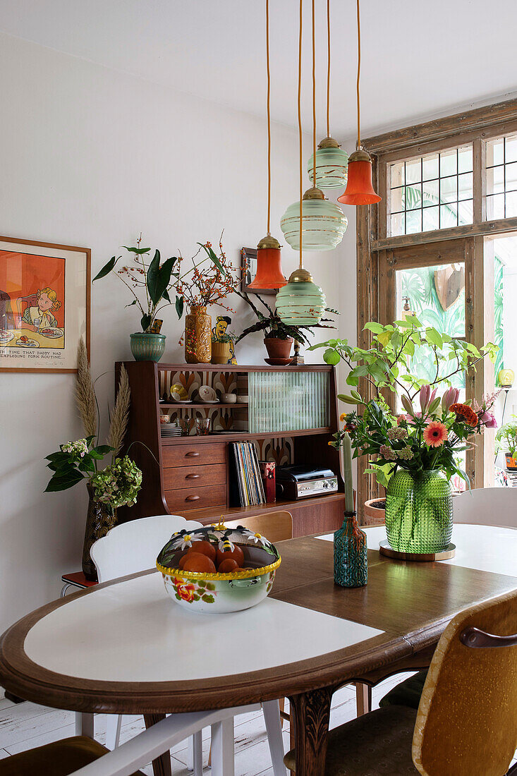 Esszimmer mit Vintage-Holzmöbeln und hängenden Glaslampen