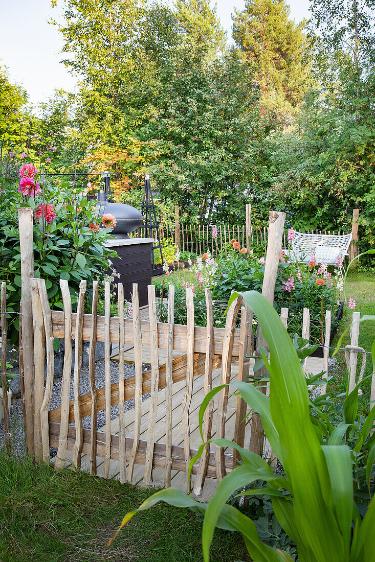 Gartenbereich mit Holzzaun und blühenden Stauden