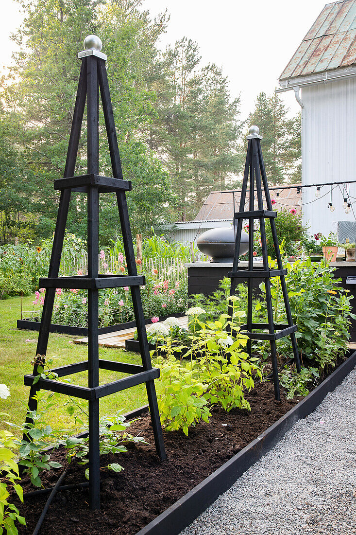 Black trellises in a modern garden bed