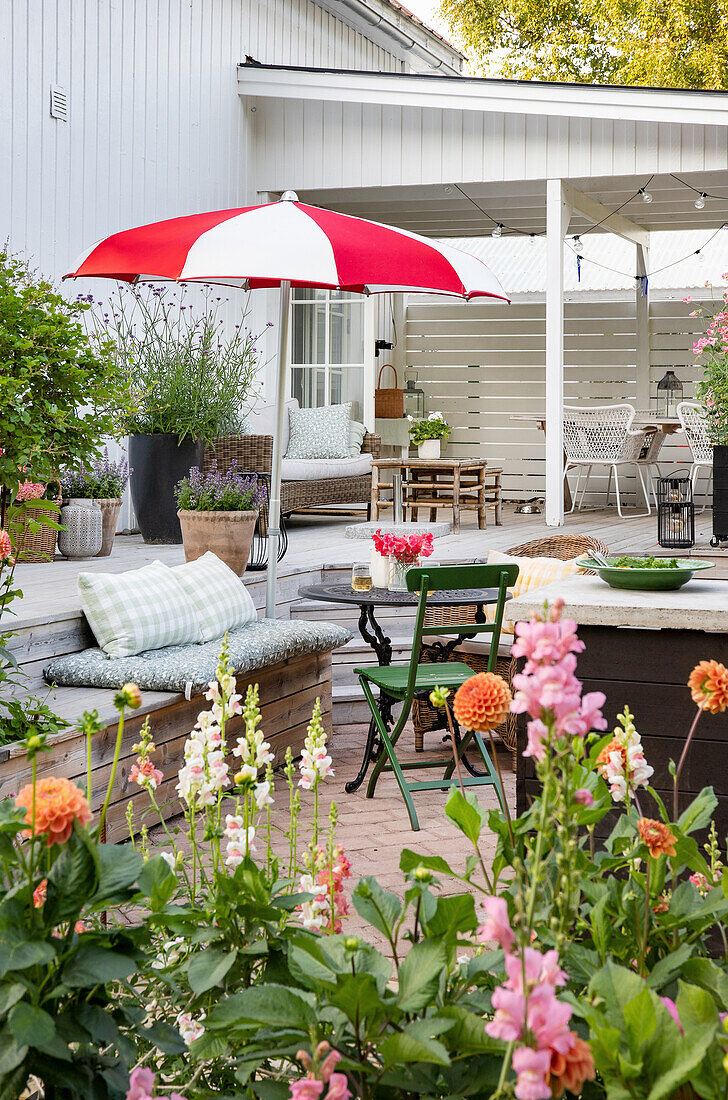 Cosy patio area with various seating areas and red parasol