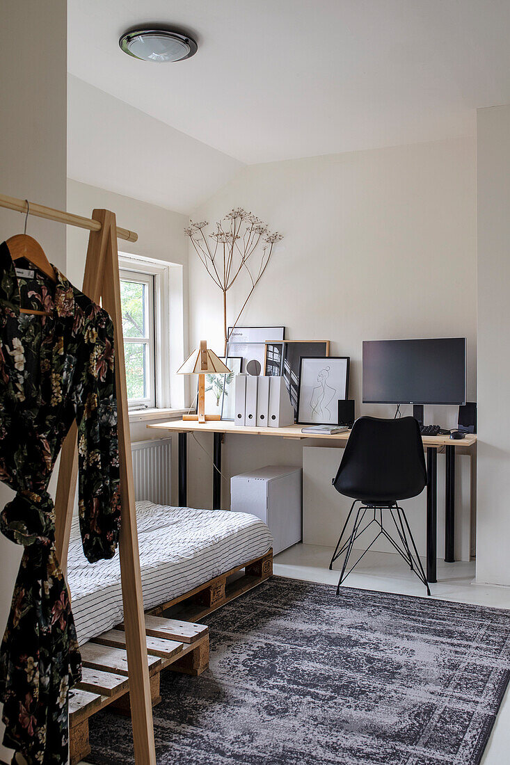 Arbeitsbereich im minimalistischen Schlafzimmer mit Holzpalettenbett