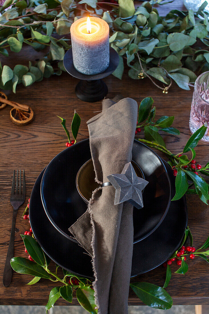 Festively laid table with star napkin ring, candle and eucalyptus