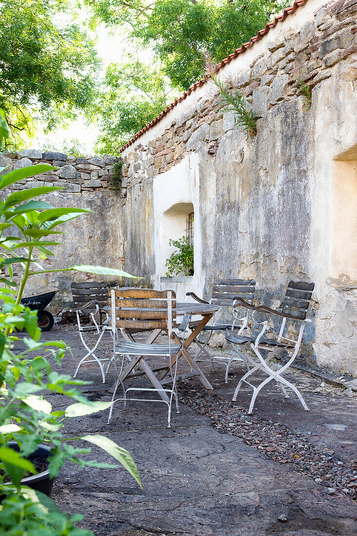 Sitzbereich mit Metallstühlen und -tisch in einem Innenhof