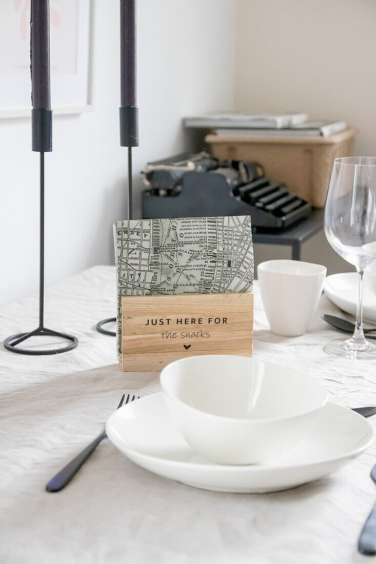 Set dining table with typewriter and decorative sign in the background