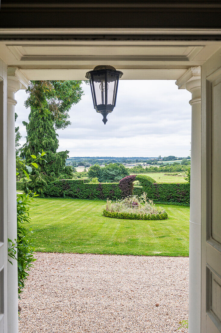 Ausblick auf einen gepflegten Garten vom Eingangsbereich eines Landhauses