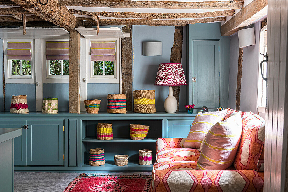 Wohnzimmer im Landhausstil mit rustikalen Deckenbalken und farbenfroher Dekoration