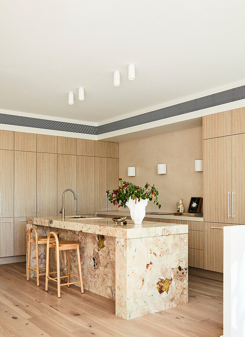 Modern kitchen with marble island and light-coloured wooden fronts