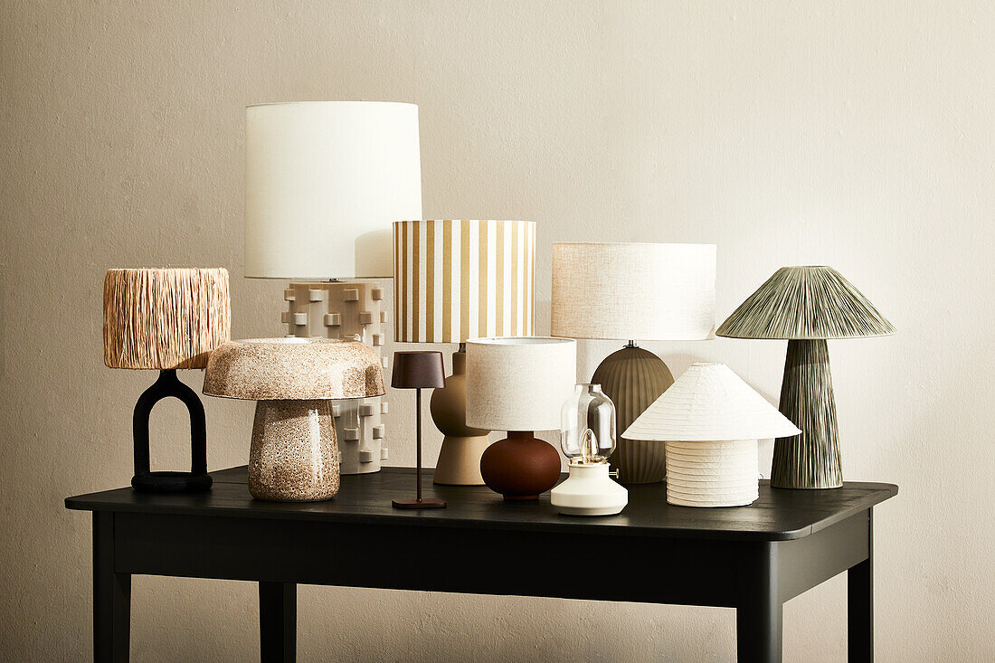 Varied table lamps made from natural materials on a dark wooden table