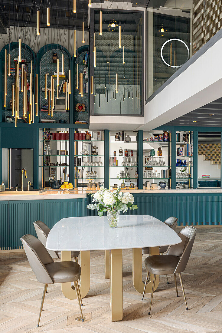 Dining area with modern table and golden chairs in open-plan kitchen