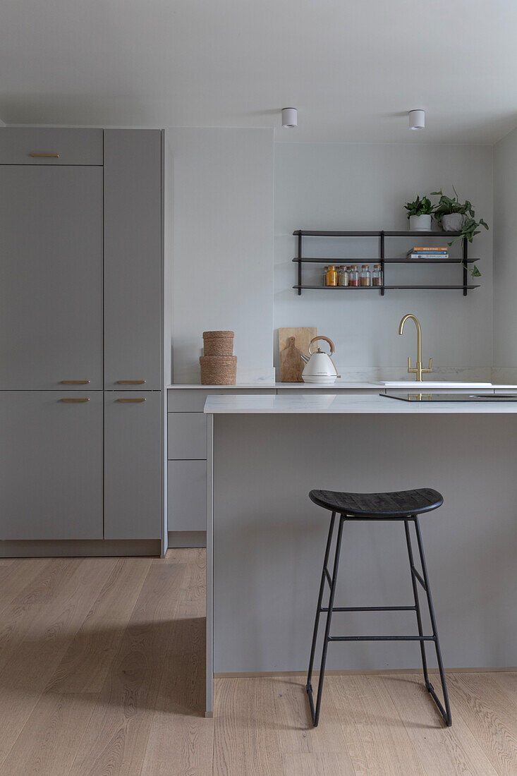 Modern kitchen with grey cabinets and black bar stool