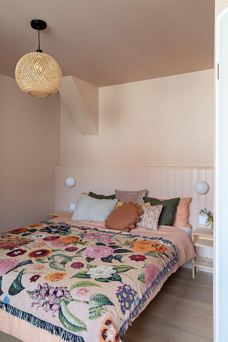 Bedroom with floral bedspread and woven ceiling light