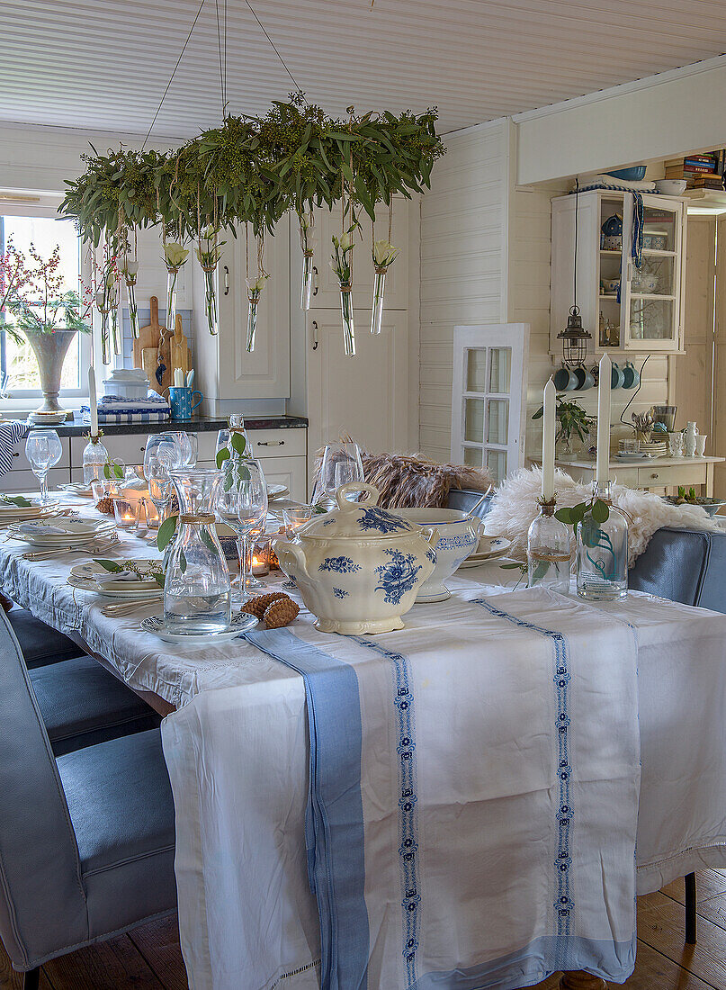 Gedeckter Esstisch mit blau-weißer Tischdecke und weihnachtlicher Deko in Landhausküche