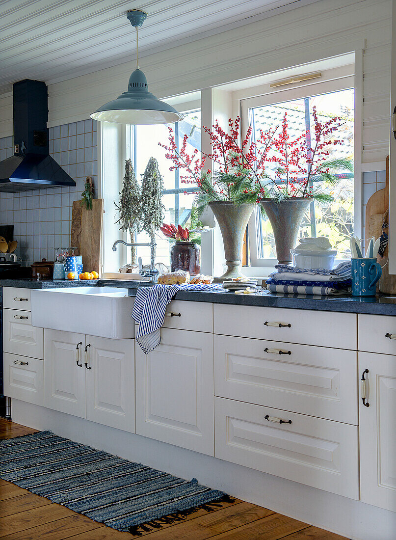 White country-style kitchen with large windows and blue accents