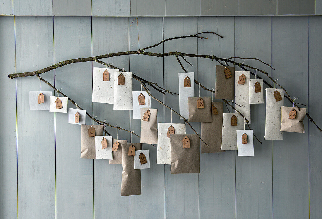 DIY-Adventskalender aus Papiertüten an einem Zweig