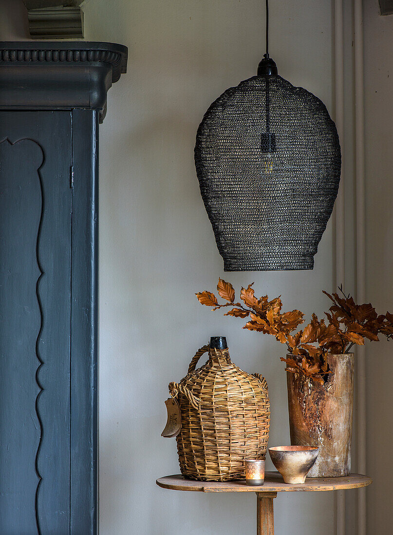 Tisch mit herbstlicher Dekoration und Lampe in einem rustikalen Raum