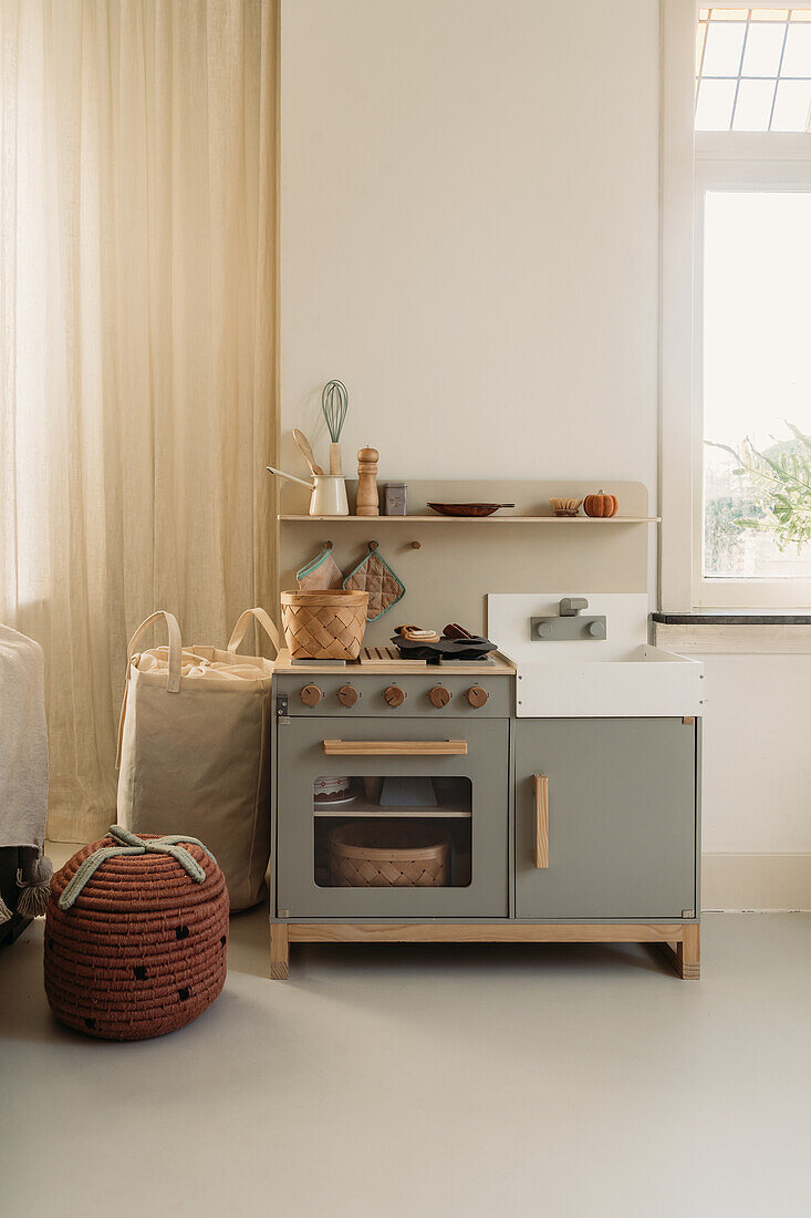 Children's kitchen and baskets next to window