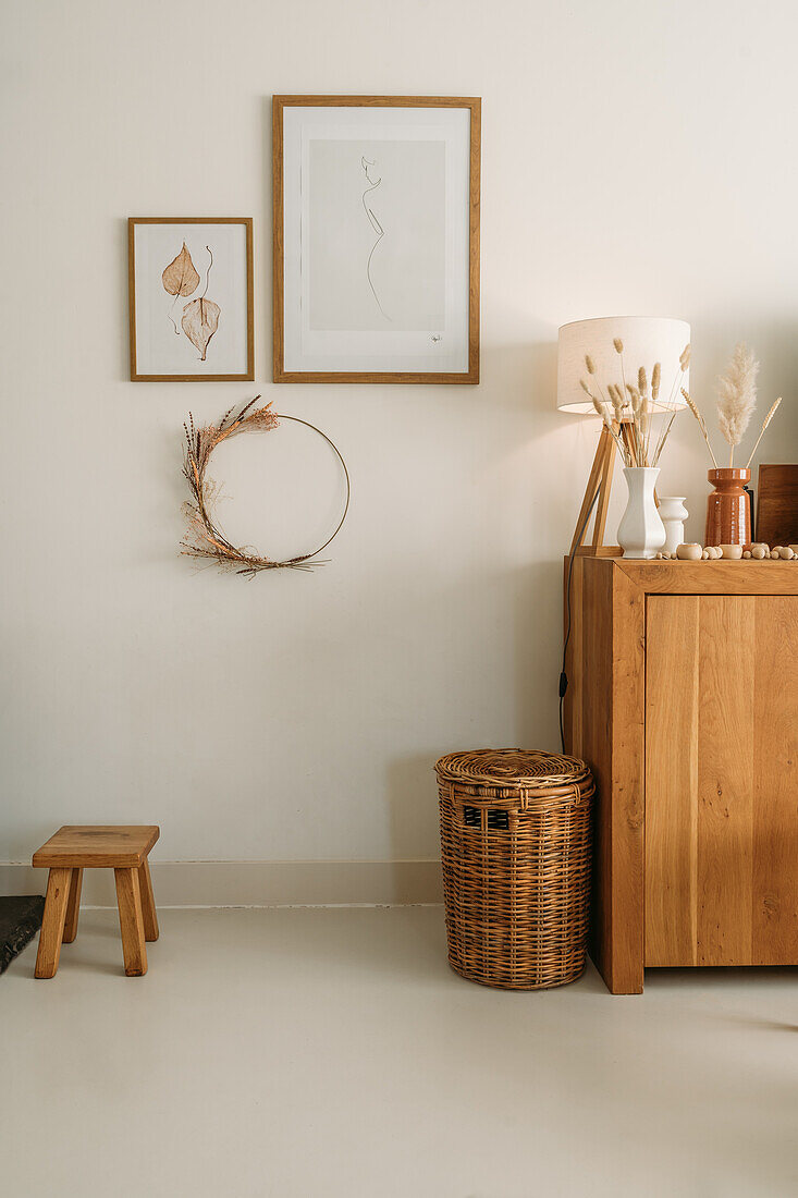 Minimalist living room with wooden chest of drawers, natural materials and rattan basket