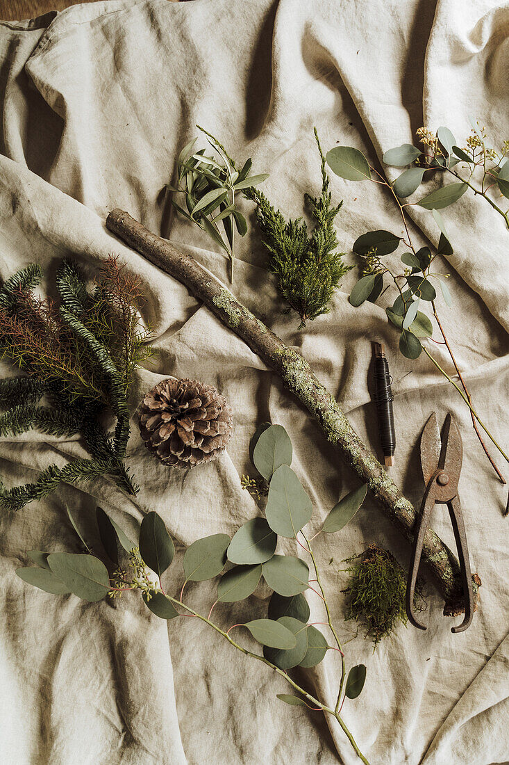 Materials for natural decorations and antique secateurs on linen fabric