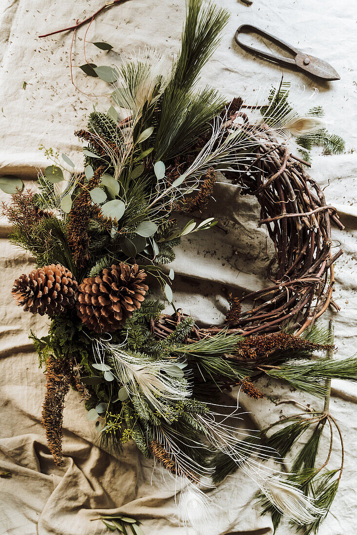 DIY-Kranz aus Naturmaterialien mit Zapfen und Zweigen