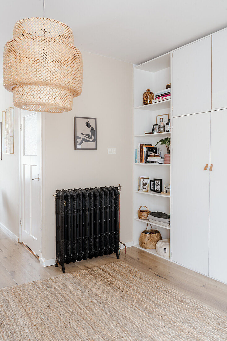 Bright hallway with black radiator and woven hanging lamp