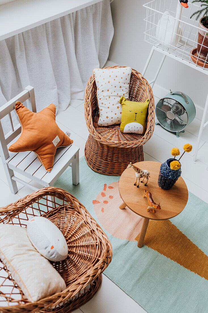 Playroom with rattan armchairs, colourful carpet and child-friendly decorations