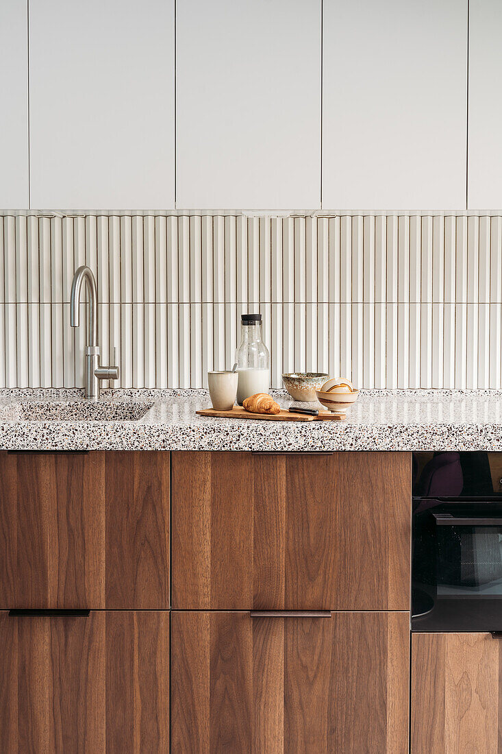 Kitchen unit with wooden fronts and terrazzo worktop, breakfast arrangement