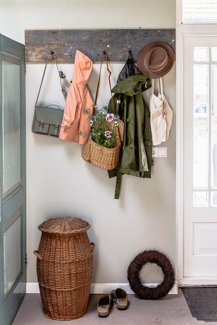 Coat rack made from a rustic wooden board and basket in the hallway