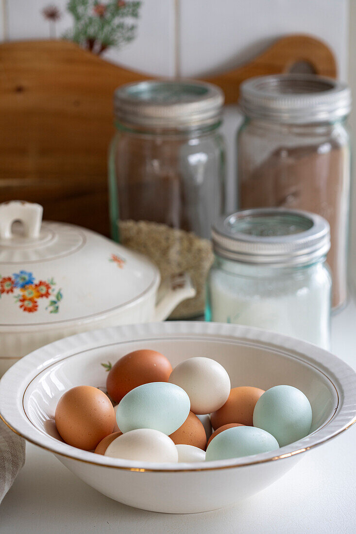 Bowl with blue, white and brown eggs in a country house kitchen