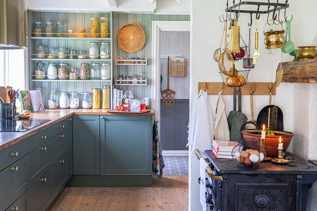 Country kitchen with green cabinets and rustic wood-burning stove