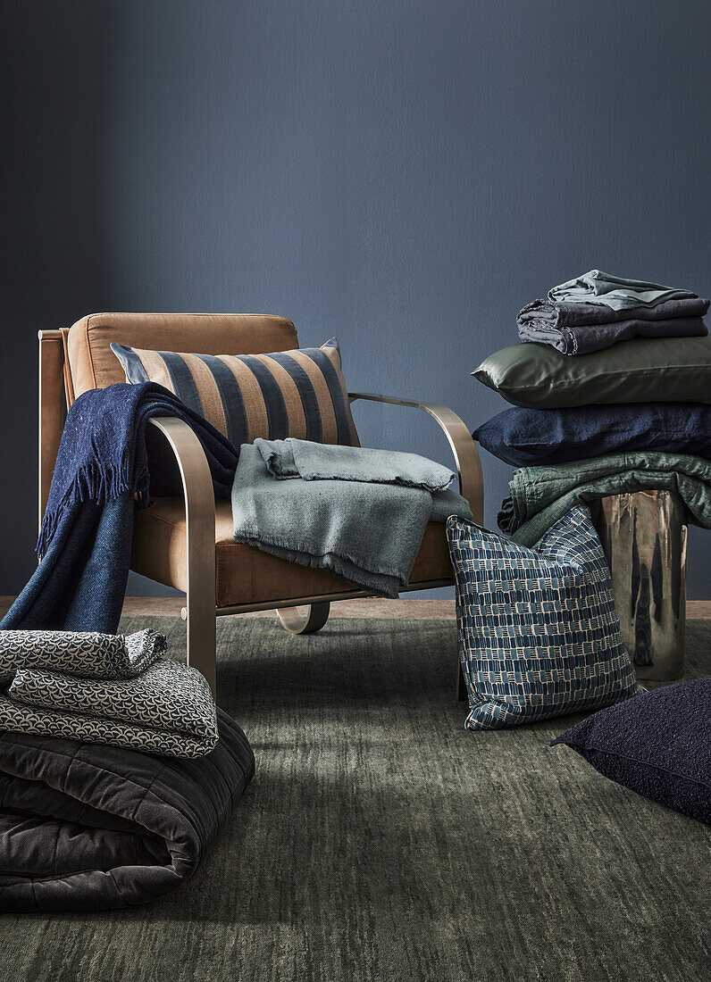 Armchair with cushions and blankets on carpet