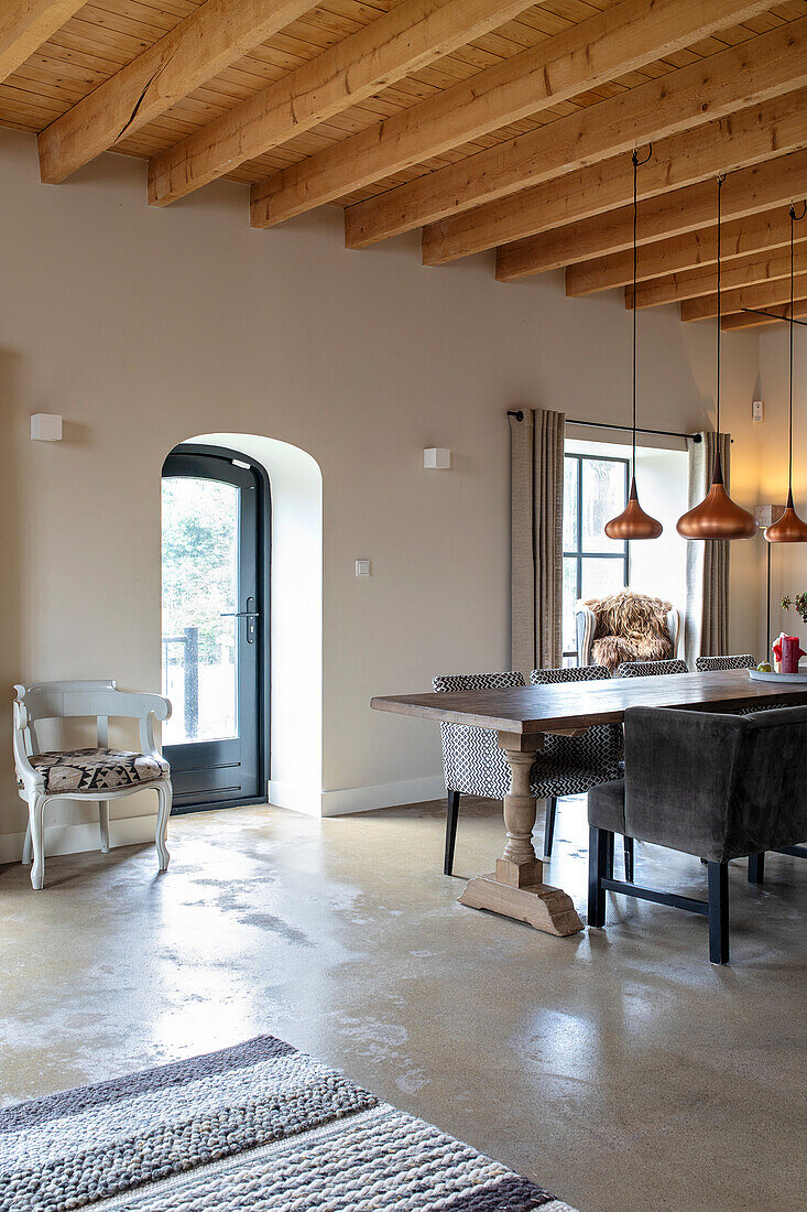 Dining area with wooden table, stone floor and wooden beamed ceiling