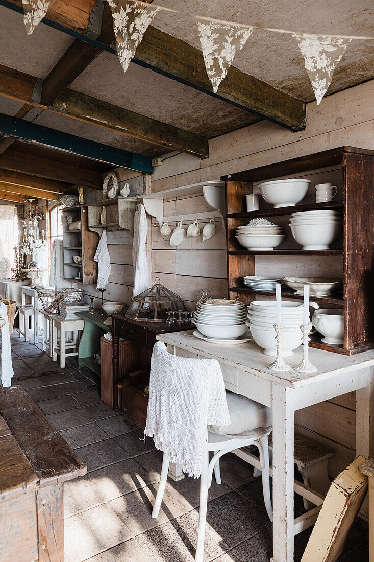 Country kitchen with rustic wooden furniture and white crockery