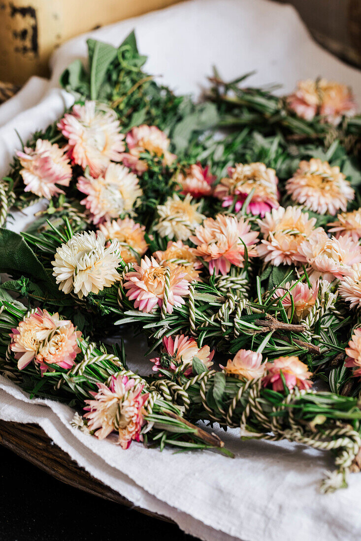 Strawflowers and sprigs of rosemary on linen cloth