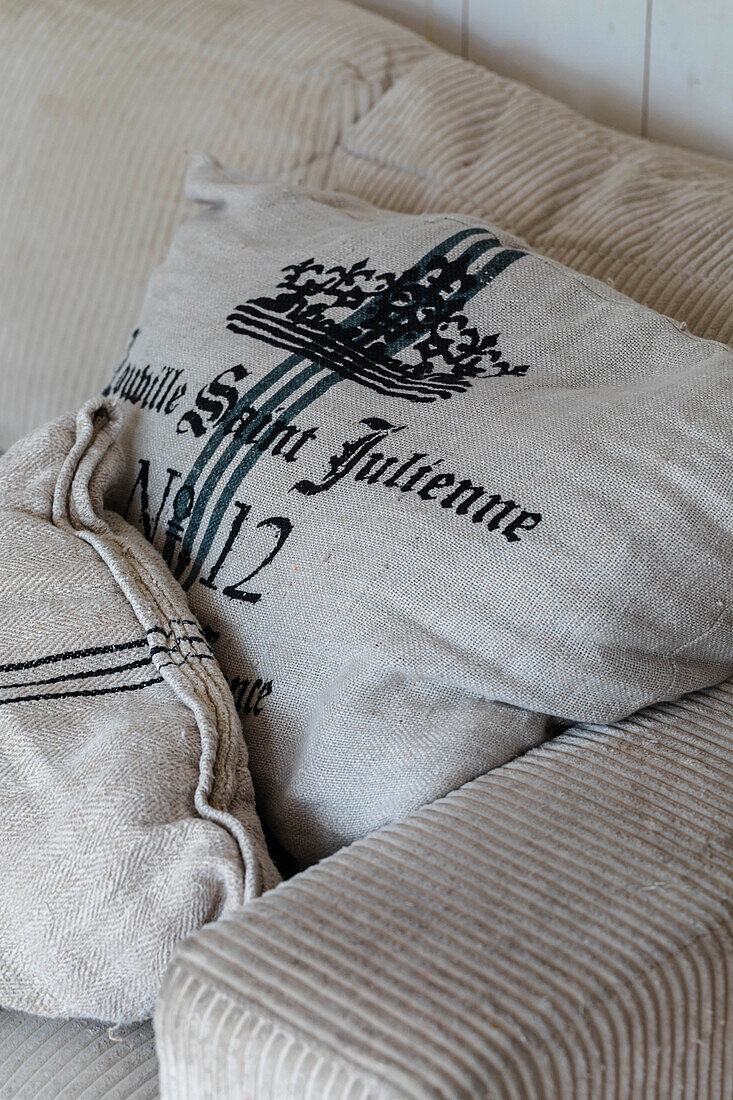 Decorative linen cushion with print on corduroy sofa