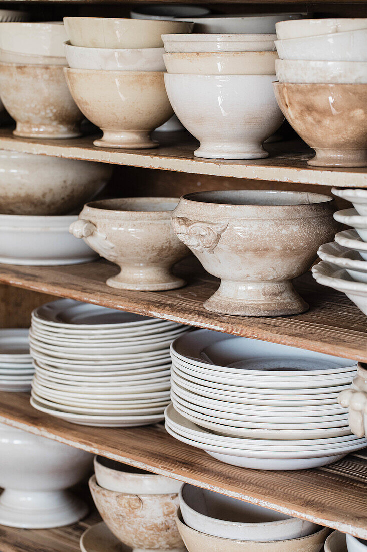 Shelves with vintage ceramic crockery in neutral tones