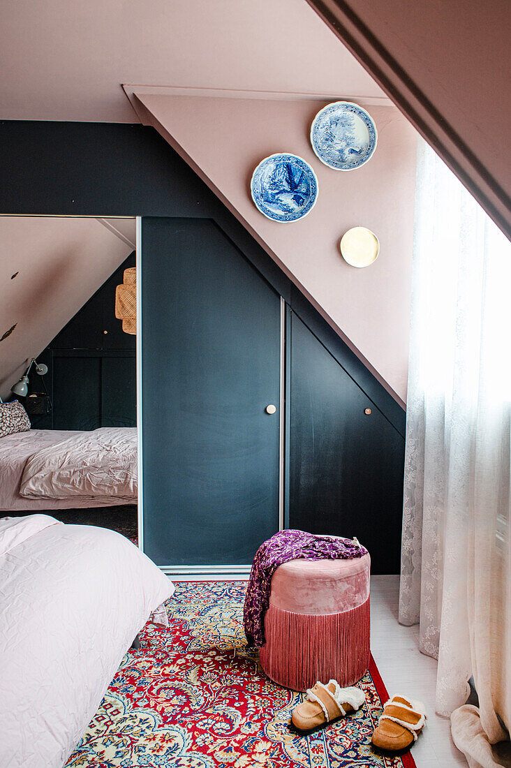 Attic room with oriental rug, built-in wardrobe and wall plates