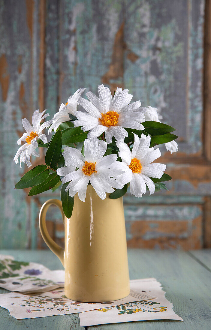 Bouquet of paper flowers in yellow vase