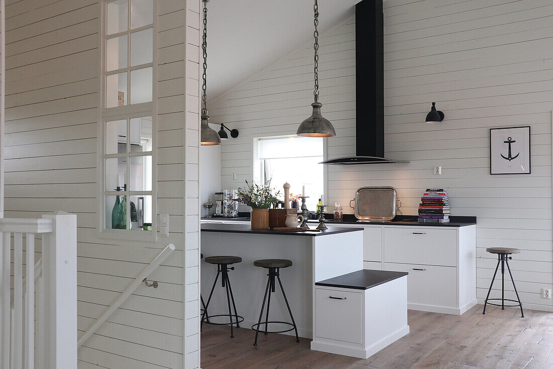 Kitchen in black and white with kitchen island and bar stools