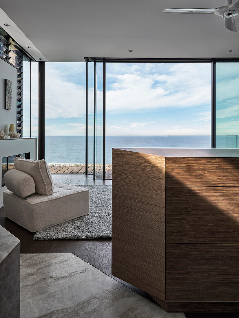 Room with panoramic sea view, floor-to-ceiling windows and cozy armchair