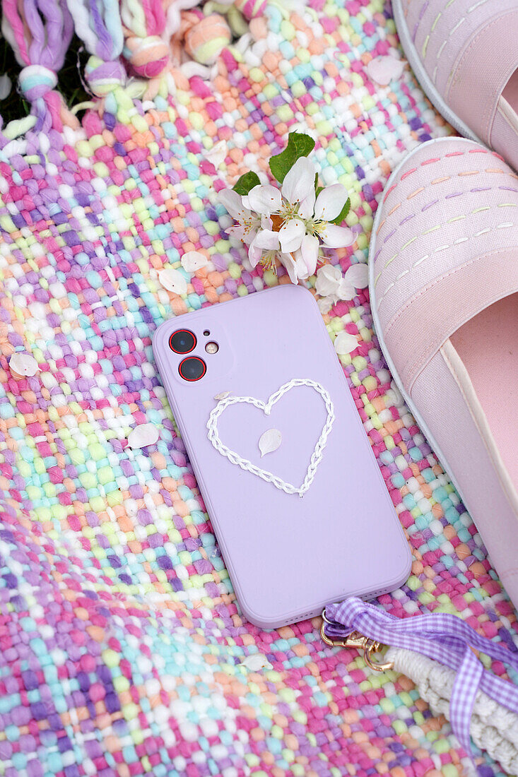 Colourful picnic blanket with embroidered smartphone cover and spring flowers