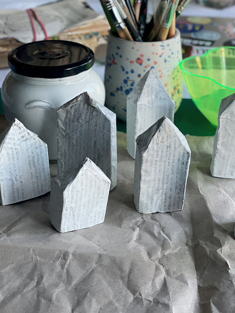 Small houses made from toilet paper rolls and book pages as Christmas decorations