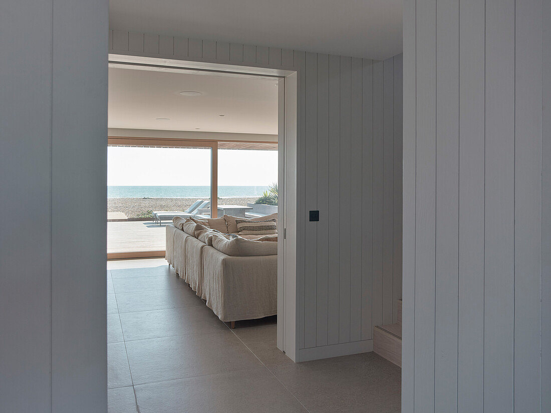 Open-plan living room with sea view and light-colored wooden walls