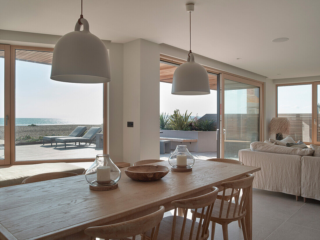 Dining area with wooden table and view of the terrace and beach