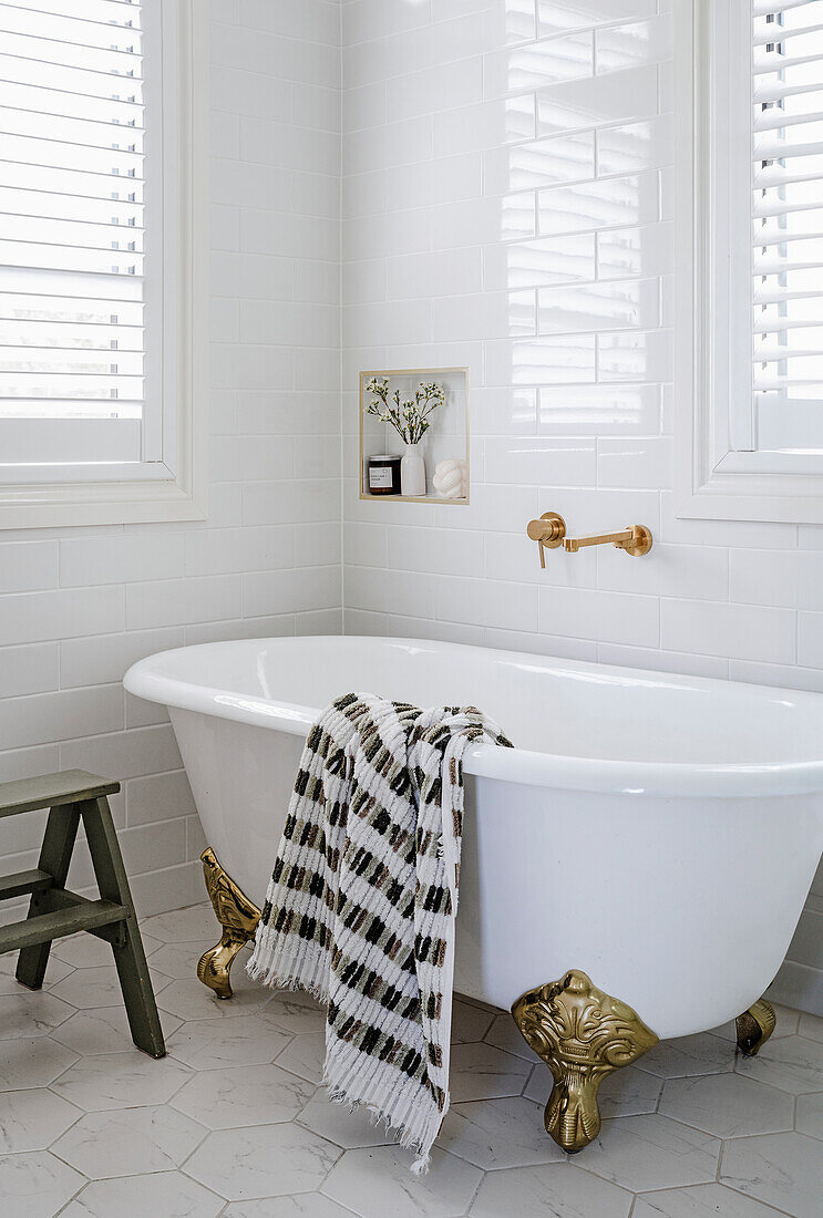 Bathtub with golden lion feet and checkered towel