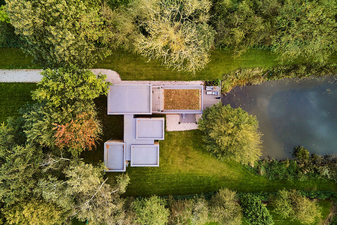 Luftaufnahme eines Hauses mit begrüntem Dach und Teich, UK