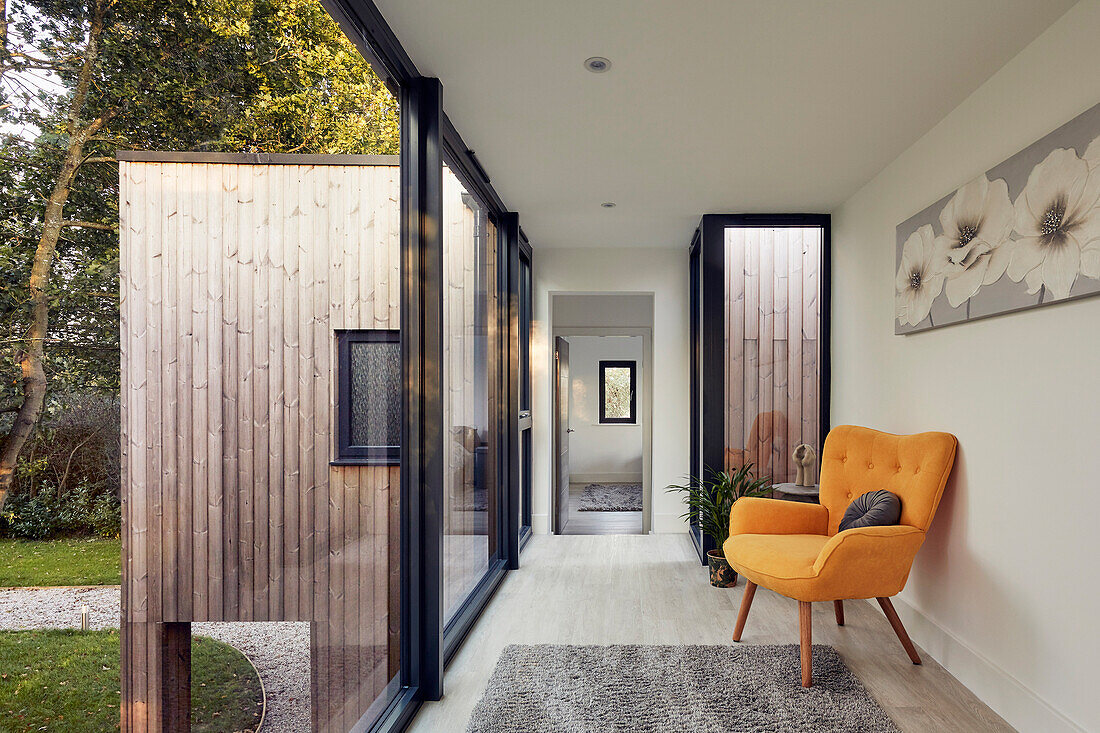 Yellow armchair in the light-flooded hallway with a view outside