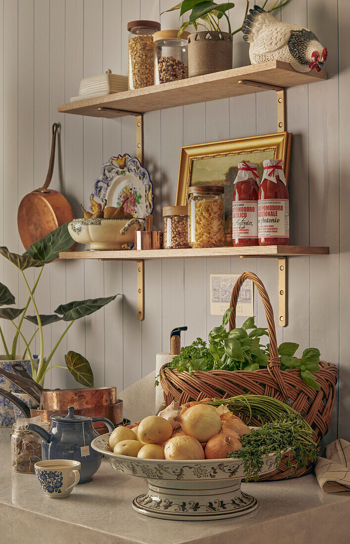 Shelf with storage jars, plant and picture, basket with herbs