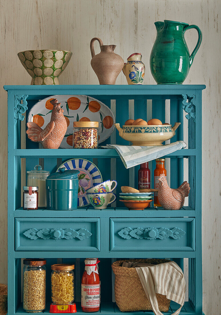 Blue kitchen shelf with ceramic crockery and storage jars